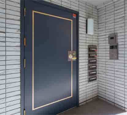 写真：マンションのドアと、そばにあるポスト、そして右手にあるインターフォン